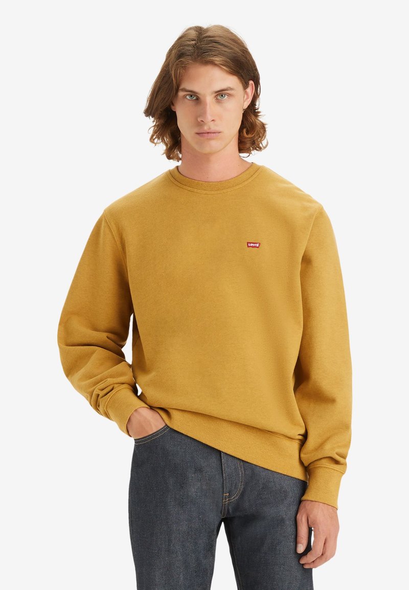 Mosterdgele sweatshirt met een ronde halslijn, lange mouwen en een klein rood Levi's logo op de borst. Zachte stoftextuur.