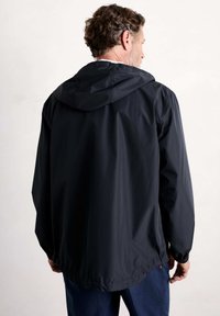 Svart lättviktsjacka med huva, med långa ärmar och dragsko i nederkant. Slät textur och minimalistisk design utan synliga logotyper.