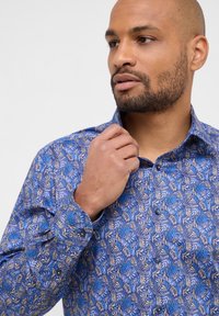 Blauw patroonshirt met een bladontwerp in verschillende tinten blauw en beige. De stof is lichtgewicht met een button-down kraag.
