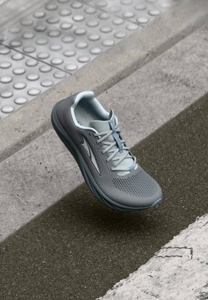 Chaussure de sport légère en matériau en maille grise avec un design texturé, dotée d'une accentuation bleu clair et d'une semelle en caoutchouc flexible.
