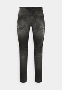 Black denim skinny jeans with a faded finish, five pockets, and contrasting stitching. Features a straight cut and minimalistic design.