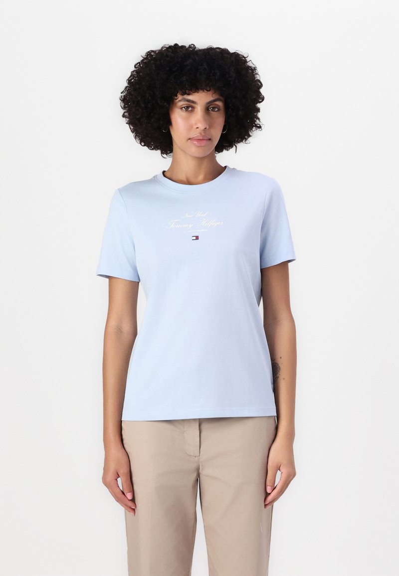T-shirt en coton bleu clair avec des manches courtes, un col rond et le logo brodé « New York Tommy Hilfiger » à l'avant.