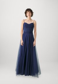Rochie de seară bleu marin, cu un corset ajustat, cute, bretele subțiri și o fustă fluidă din tul transparent, creând o siluetă stratificată.