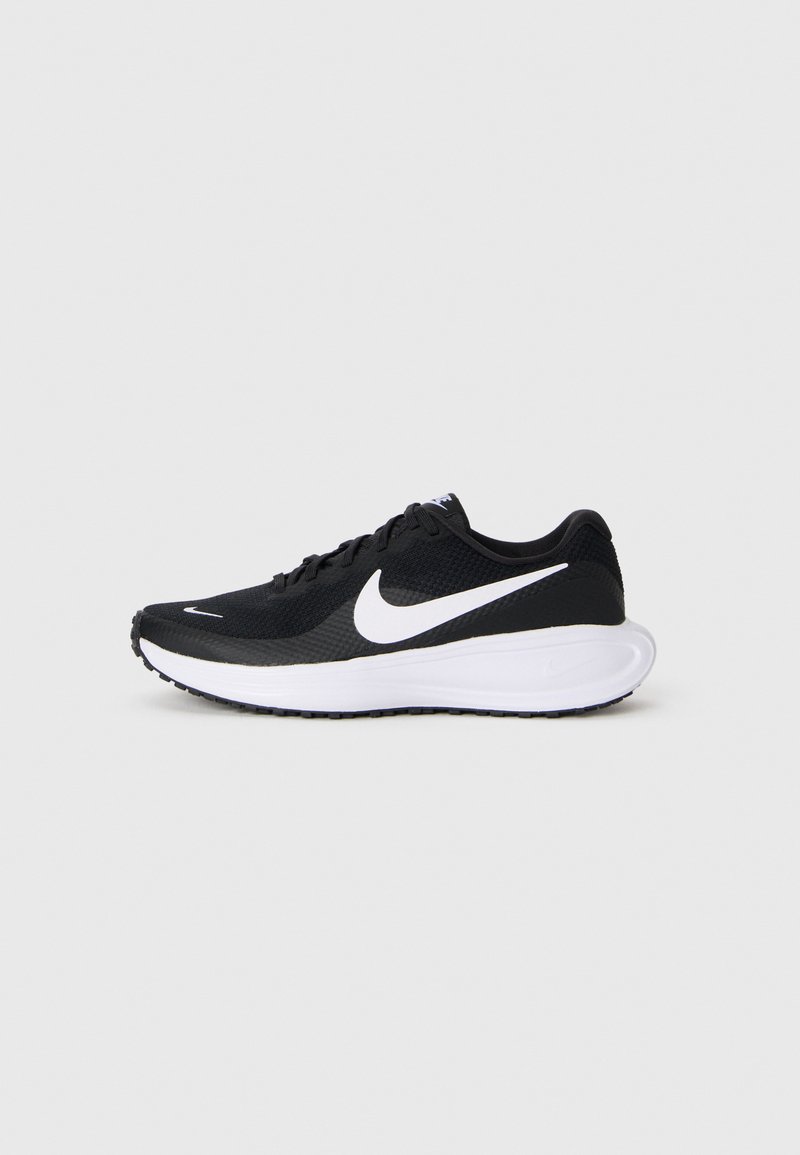 Sorte Nike joggesko med hvit swoosh-logo og tykk hvit såle på en enkel lys grå bakgrunn.