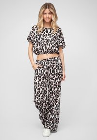 Kraťasový top s leopardím vzorom a elastickým pásom spárovaný s wide-leg nohavicami, oboje vyrobené z jemnej látky, s voľným strihom a vreckami.