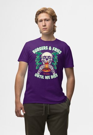 Paarse katoenen T-shirt met een afbeelding van een skelet dat een burger vasthoudt, in levendige kleuren en de tekst: "BURGER & FRITES TOT WE DOODGAAN."