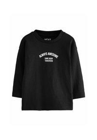 T-shirt noir en coton à manches longues avec un col rond et un texte blanc : "TOUJOURS FORMIDABLE" au-dessus de "MÊME CHOSE DEMAIN." Coupe classique.