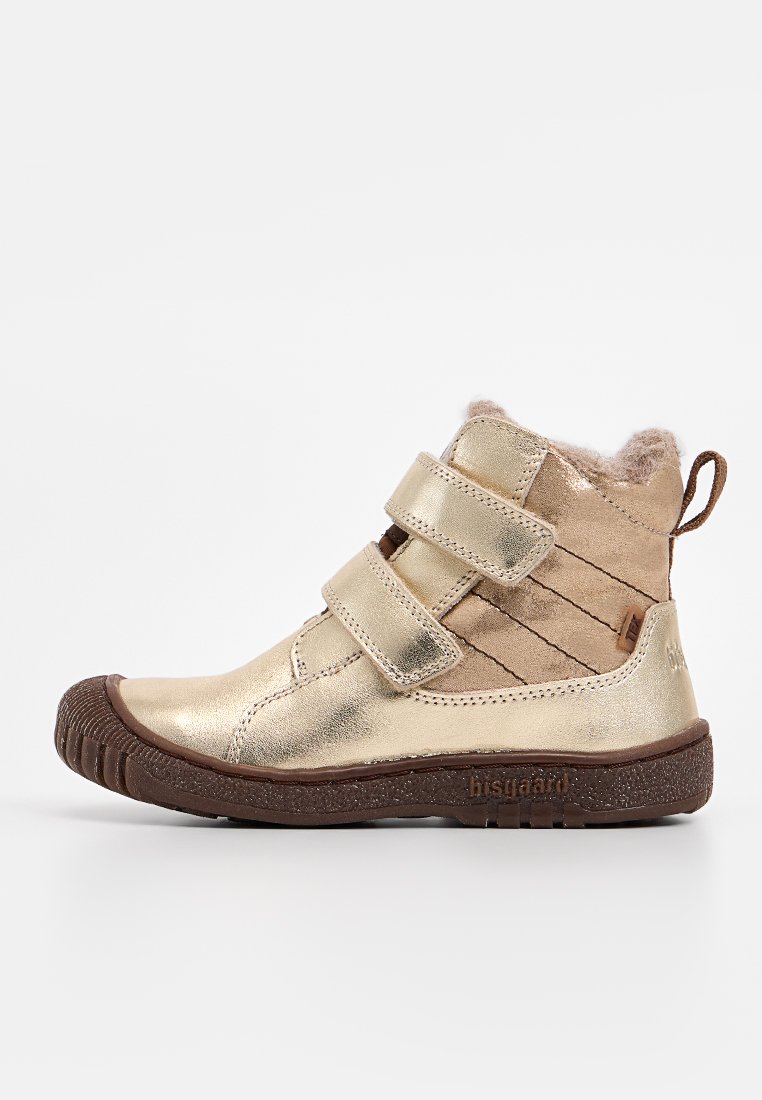 Goldene metallische Knöchelstiefel mit zwei Klettverschlussriemen, gefüttert mit Kunstfell und einer strukturierten braunen Außensohle für besseren Halt.