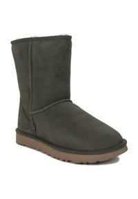 Groene suède enkellaars met een zachte voering, vlakke rubberen zool en details aan de zijkant. Eenvoudig ontwerp zonder extra hardware of accenten.