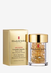 Boîte dorée avec le logo "Elizabeth Arden", contenant un pot transparent rempli de capsules dorées en forme de dôme étiquetées "Capsules de Céramide Pour la Jeunesse Quotidienne".