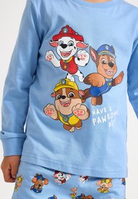 Light blue long-sleeve shirt featuring cartoon dogs in red, yellow, and blue uniforms, with "Have a Pawsome Day!" printed below.