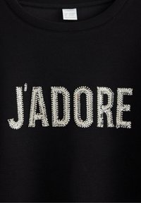 Sort t-shirt med ordet "J'ADORE" i store, skinnende rhinsten. Glat stof med rund halsudskæring og korte ærmer.