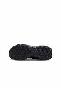 Suela de zapato negra con goma texturizada y un patrón ondulado, diseñada para tracción y agarre; bordes redondeados con un material resistente y duradero.