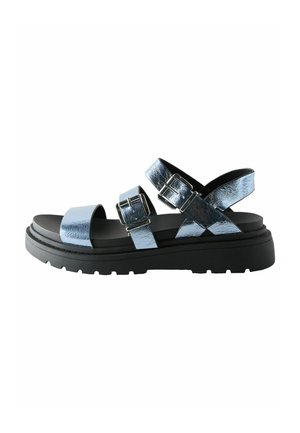 Blue metallic sandals with cross straps, adjustable buckles, and a thick black sole featuring a textured tread.