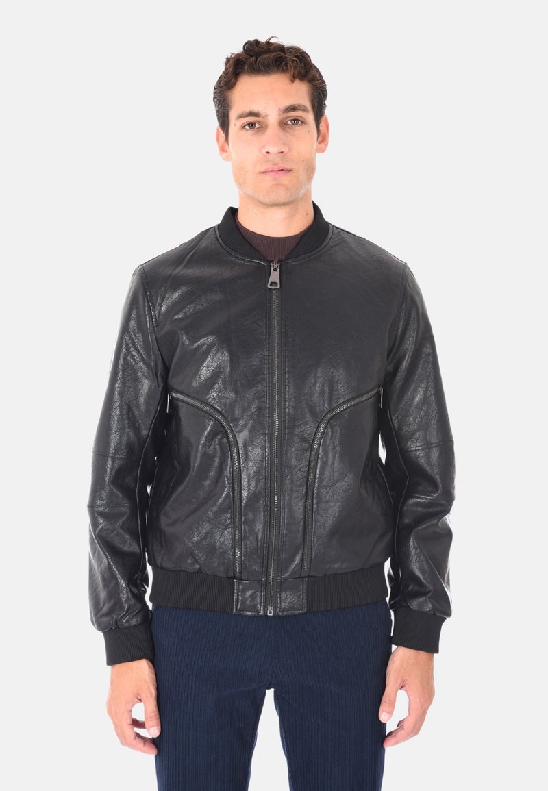 Giacca bomber in pelle nera con finitura liscia e strutturata, polsini a coste e due tasche anteriori con zip. Chiusura con zip frontale.