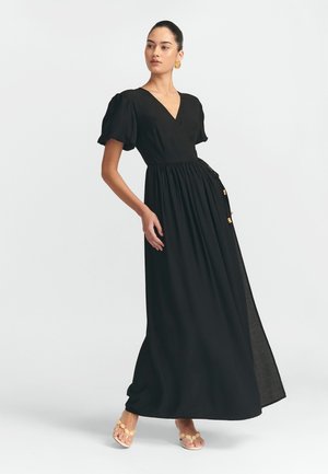 Schwarzes Maxikleid mit puffärmel, tiefem V-Ausschnitt, taillierter Taille und seitlicher Schlitze, aus leichtem Stoff gefertigt. Mit Kordelzugdetails akzentuiert.