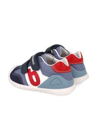 Scarpe in velcro blu e rosse con tomaia in tessuto testurizzato, suola intermedia bianca e suola in gomma. Presentano blocchi di colore a contrasto e marchio.