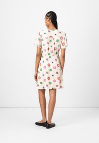 Short-sleeve dress in light cream fabric, featuring colorful floral patterns in pink, blue, and green, with an elastic waist and flared hem.