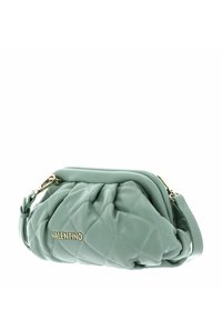 Grön läderväska med vadderat mönster och guldlogotyp, med dragkedjestängning och avtagbar axelrem för mångsidiga bäralternativ.