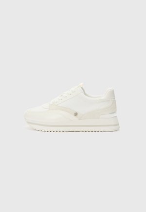 Baskets basses blanches avec fermeture à lacets, semelle texturée et détail discret du logo sur le côté, présentées sur un fond uni.