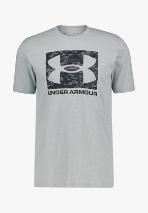 Graues T-Shirt mit kurzen Ärmeln aus Baumwolle, das ein schwarzes und graues Camouflage-Logo von Under Armour in einer rechteckigen Grafik auf der Vorderseite zeigt.