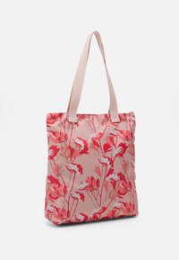 Sac fourre-tout floral avec un fond rose, des motifs de fleurs rouges et blanches, et des poignées rose clair, fabriqué en tissu léger.
