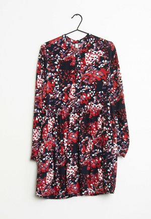 Florales Kleid mit langen Ärmeln, runden Ausschnitt und Knopfverschluss. Das Muster zeigt rote, violette und weiße Formen auf einem marineblauen Hintergrund.