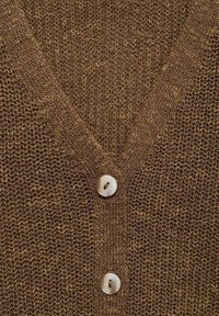 Brązowy dzianinowy kardigan z dekoltem w serek, z trzema okrągłymi, drewnianymi guzikami na przodzie, podkreślający teksturowany, otwarty wzór ściegów.