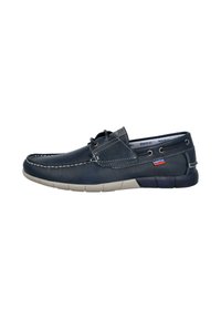 Zapato náutico de cuero azul marino con costuras blancas, puntera redonda, diseño con cordones y suela de goma beige. Presenta una pequeña etiqueta en el lateral.
