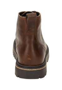 Stivale ankle in pelle marrone con punta rotonda, dettagli di cucitura minimi, una linguetta sul retro e una suola in gomma robusta.