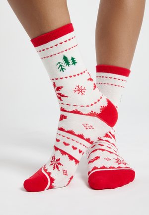 Red and white patterned socks featuring trees, snowflakes, and hearts. Made of soft fabric with a red cuff and toe for contrast.