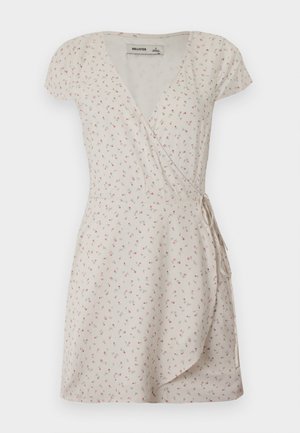 Robe courte crème à enfiler avec un petit imprimé floral rose et des manches courtes, nouée à la taille.