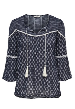 Blusa azul marino con estampado floral blanco, mangas acampanadas 3/4, lazos con borlas en el escote en V y detalles de ribete blanco en el pecho y las mangas.