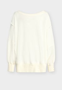 Ekrasti džemper s dugim rukavima s rebrastim manžetama i rubom, izrezom u obliku čamca i spuštenim šavovima na ramenima na jednobojnoj svijetloj pozadini.