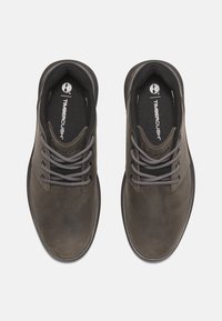 Scarpe Timberland in pelle marrone scuro con texture liscia, punta rotonda, lacci grigi e colletto imbottito, dotate di soletta TimberCush™.