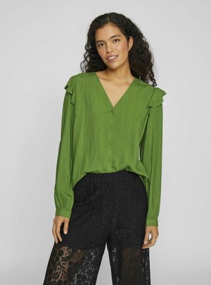 Green button-up blouse with a V-neck, ruffled shoulder accents, and long sleeves, paired with black lace pants featuring floral patterns.