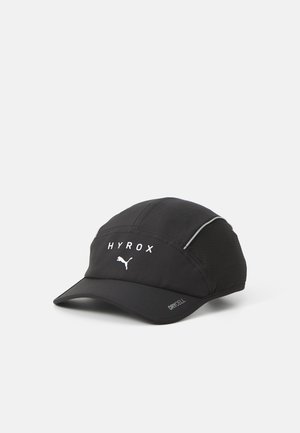 Zwarte pet met een gebogen kroon, voorzien van "HYROX" en het Puma-logo in het wit. Gemaakt van ademend materiaal met netpanels voor ventilatie.