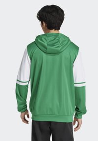 Felpa con cappuccio verde e bianca dal design aderente e liscio. Presenta maniche a contrasto e strisce sui gomiti e sul collo.
