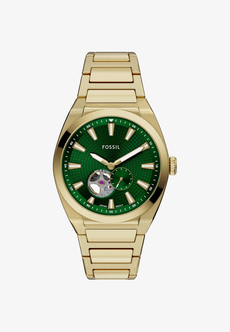 Montre-bracelet Fossil en métal doré avec cadran vert texturé, index lumineux, fenêtre squelette et sous-cadran des petites secondes.
