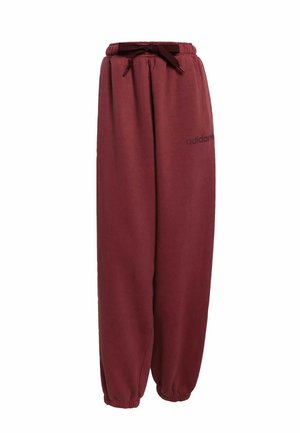 Pantaloni da jogging bordeaux con vita elastica e cordoncino. Caviglie a costura e branding minimale sulla gamba sinistra. Tessuto morbido e liscio.