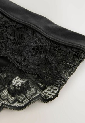 Zwarte kleding met een glad bovenste gedeelte en complexe zwarte kantdetails eronder, met bloempatronen en een gegolfde rand.