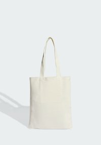 Platnena torba u boji slonovače, pravokutnog oblika, s dvostrukim naramenicama i prošivenim detaljima na gornjim rubovima. Glatka tekstura.