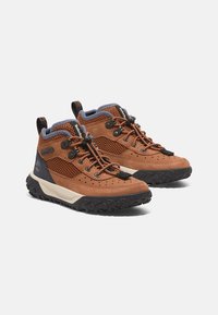 Scarpe da trekking in suede marrone e rete con suole in gomma nera, colletto imbottito e lacci, dotate di occhielli rinforzati e dettagli con logo.