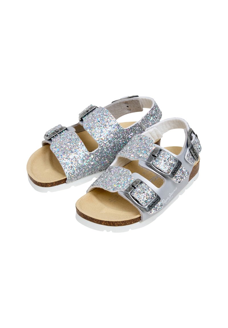 Sandalias infantiles plateadas con brillo, con dos correas ajustables con hebillas y plantillas acolchadas de corcho sobre fondo blanco.