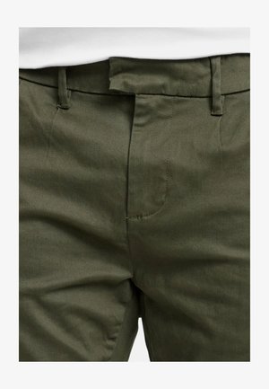 Olivgrüne Hose mit glatter Textur, ausgestattet mit einer flachen Vorderseite, Gürtelschlaufen und diskreten Nähdetails entlang der Nähte.