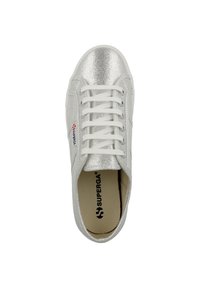 Sneaker metallico argento con una superficie liscia, lacci bianchi e un logo sul lato. Design a profilo basso con punta tonda.