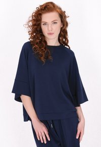 Pullover blu navy realizzato in tessuto morbido, con maniche larghe e scollatura rotonda, progettato con una vestibilità comoda.