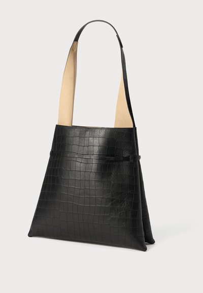 Bolso de mano de cuero negro con un patrón texturizado de cocodrilo, correas de acento en color crema y una forma triangular con una base plana.