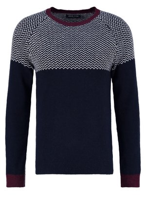 Suéter navy con patrón de zigzag blanco en la parte superior, acentos de canalé marrón en los puños y el cuello, textura de punto suave, diseño de cuello redondo.