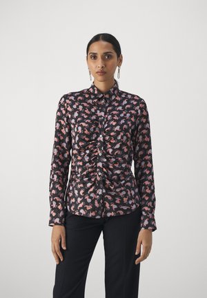 Musta paita, jossa on värikäs paisley-kuvio, etuosan rypytys, pitkät hihat ja kauluksellinen pääntie nappisuljennalla.